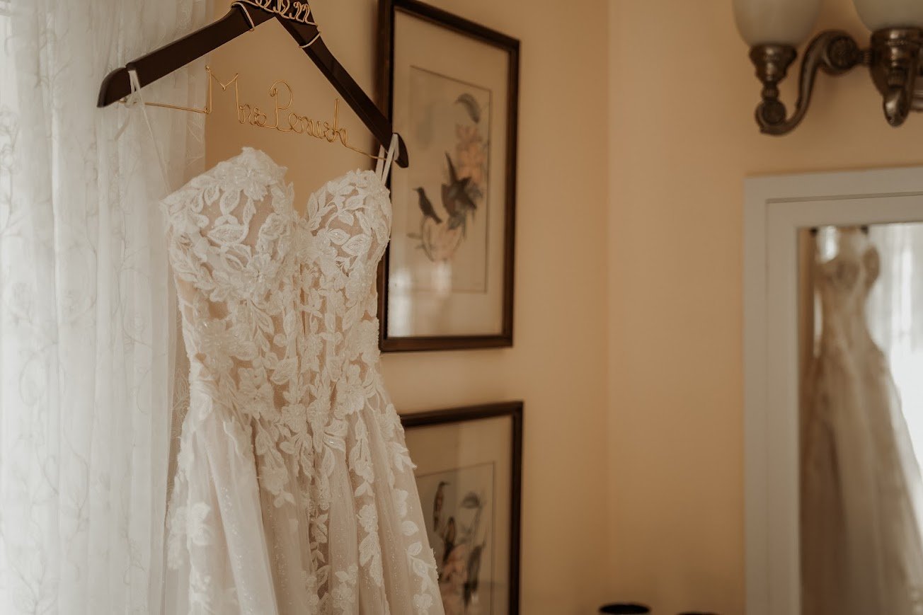 Wedding dress hanging in a softly lit room at Twickenham House & Hall