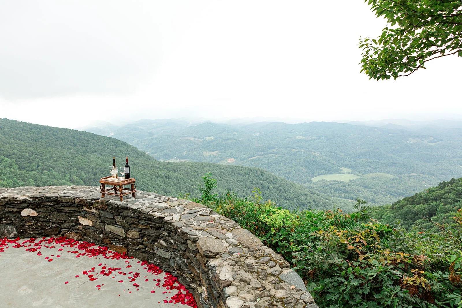 Mountain overlook wedding ceremony view with a stone terrace and misty blue ridge landscape.