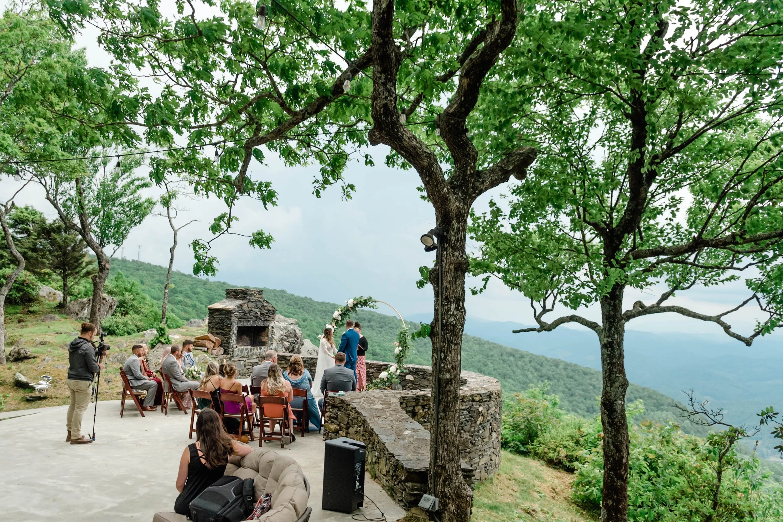 Wedding buffet setup with chafing dishes under a candle-style chandelier in a rustic venue