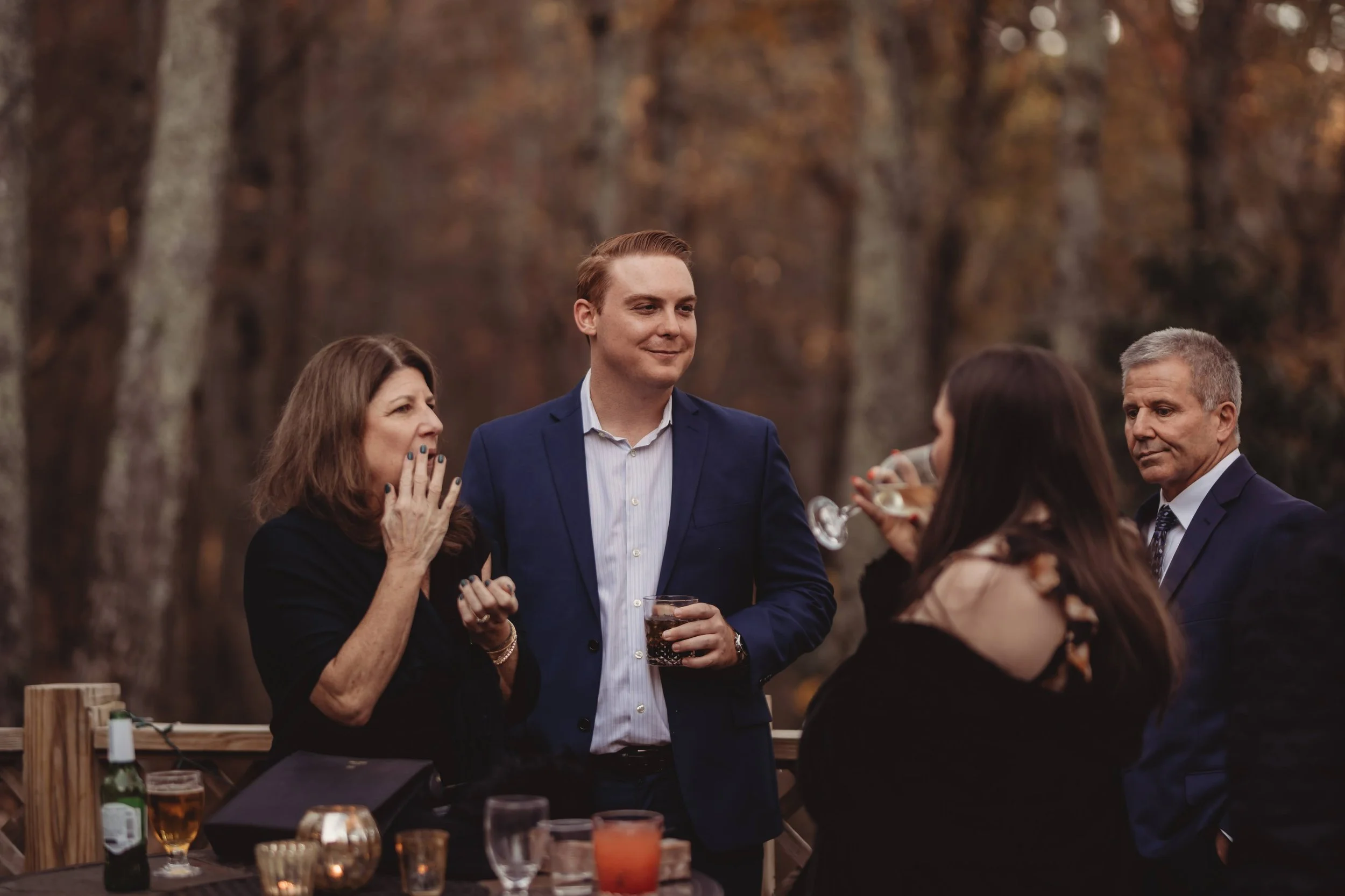 Corporate retreat attendees chatting and enjoying drinks during an outdoor fall networking reception.