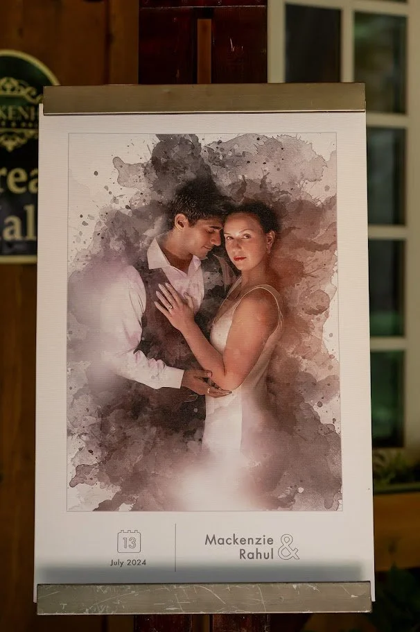 Printed watercolor-style portrait of a couple displayed on a stand, featuring their names and date at the bottom.