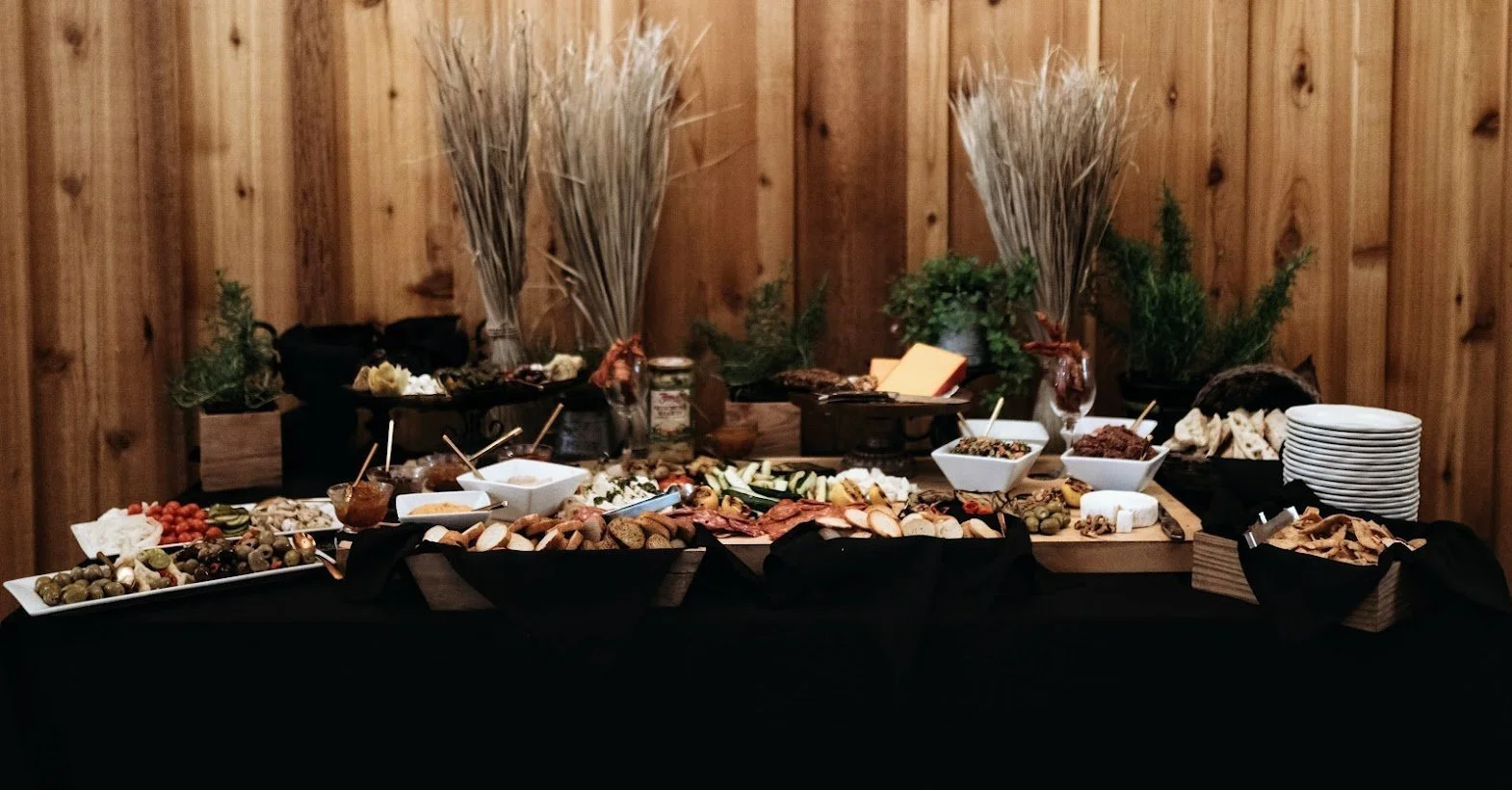 Grazing table with charcuterie, fruit, and appetizers set up for wedding cocktail hour