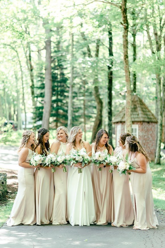 Bridesmaids standing together with bouquets for a forest wedding portrait.