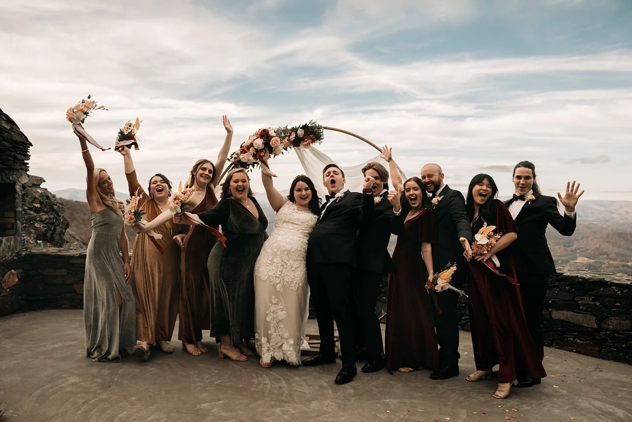 Outdoor wedding ceremony with guests seated under trees at a scenic mountain overlook