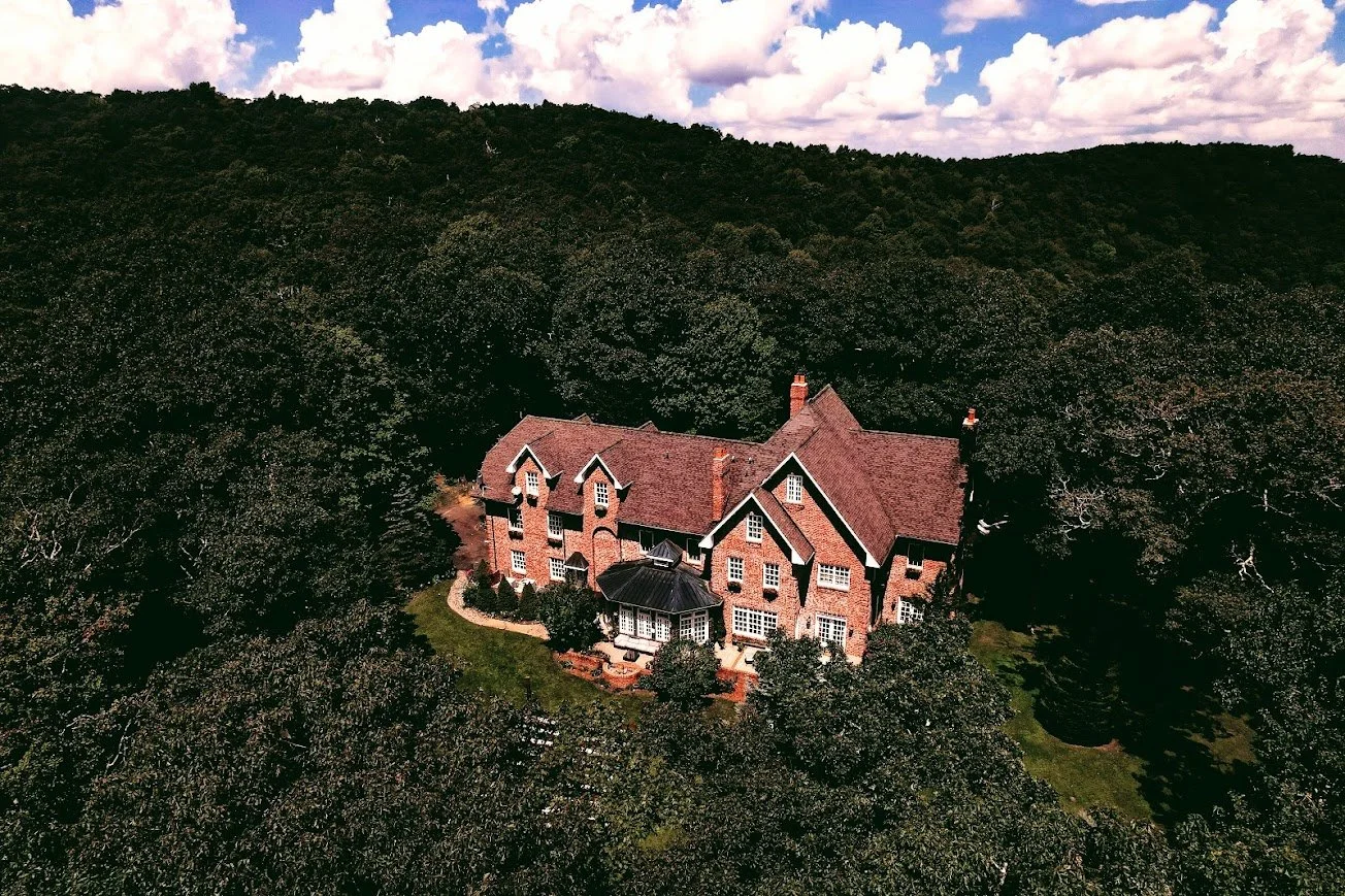 Aerial view of the Twickenham House & Hall estate surrounded by dense green forest