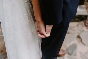 Close-up of the bride and groom holding hands during a wedding first look