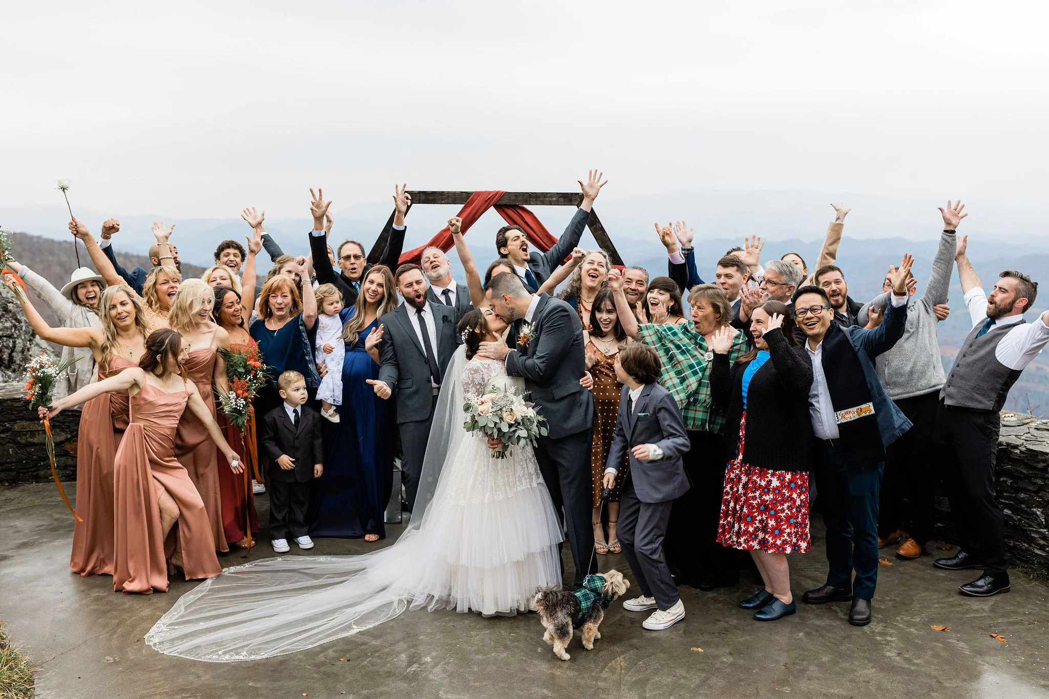 wedding-group-cheer-mountain-terrace-kiss
