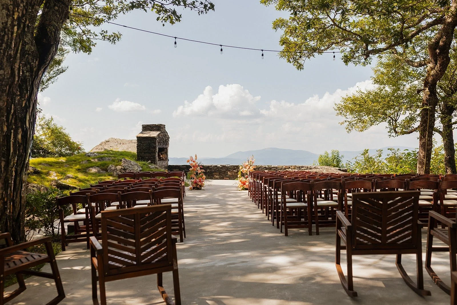 Outdoor wedding ceremony setup with rows of chairs at a mountain overlook venue.