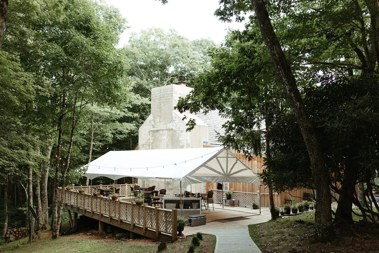 Guests taking turns at an axe-throwing target set up outdoors on the lawn