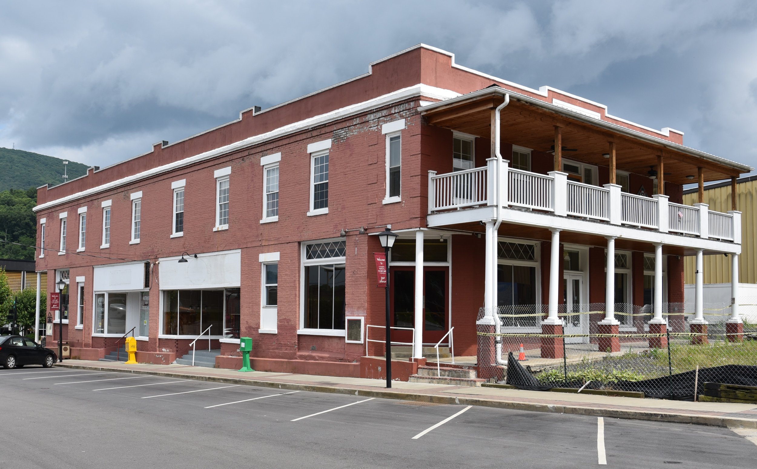 Daytime street view of the brick West Jefferson Hotel with the hotel name visible near the roofline.
