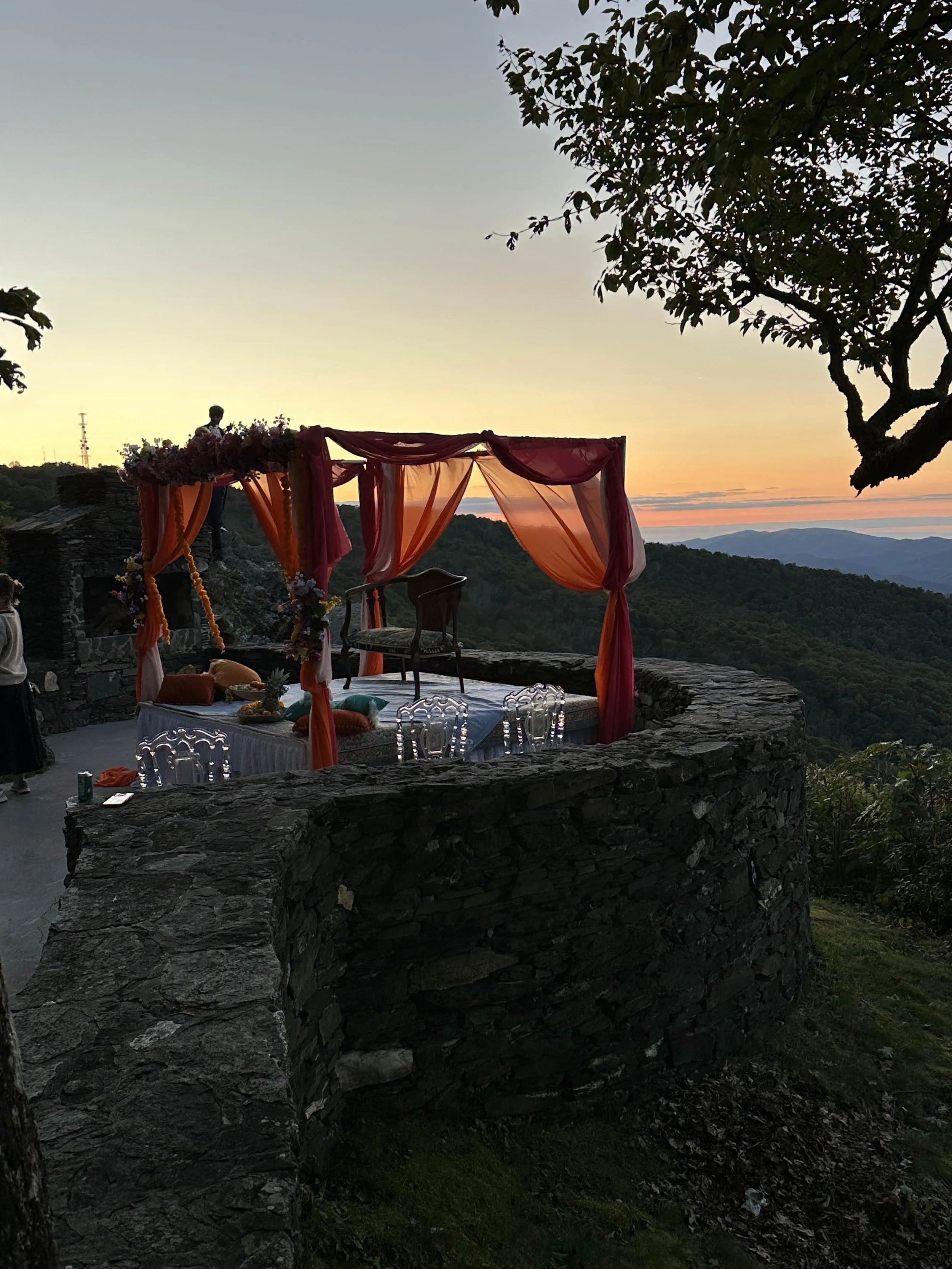 Indian wedding mandap on a stone terrace at sunset overlooking the mountains