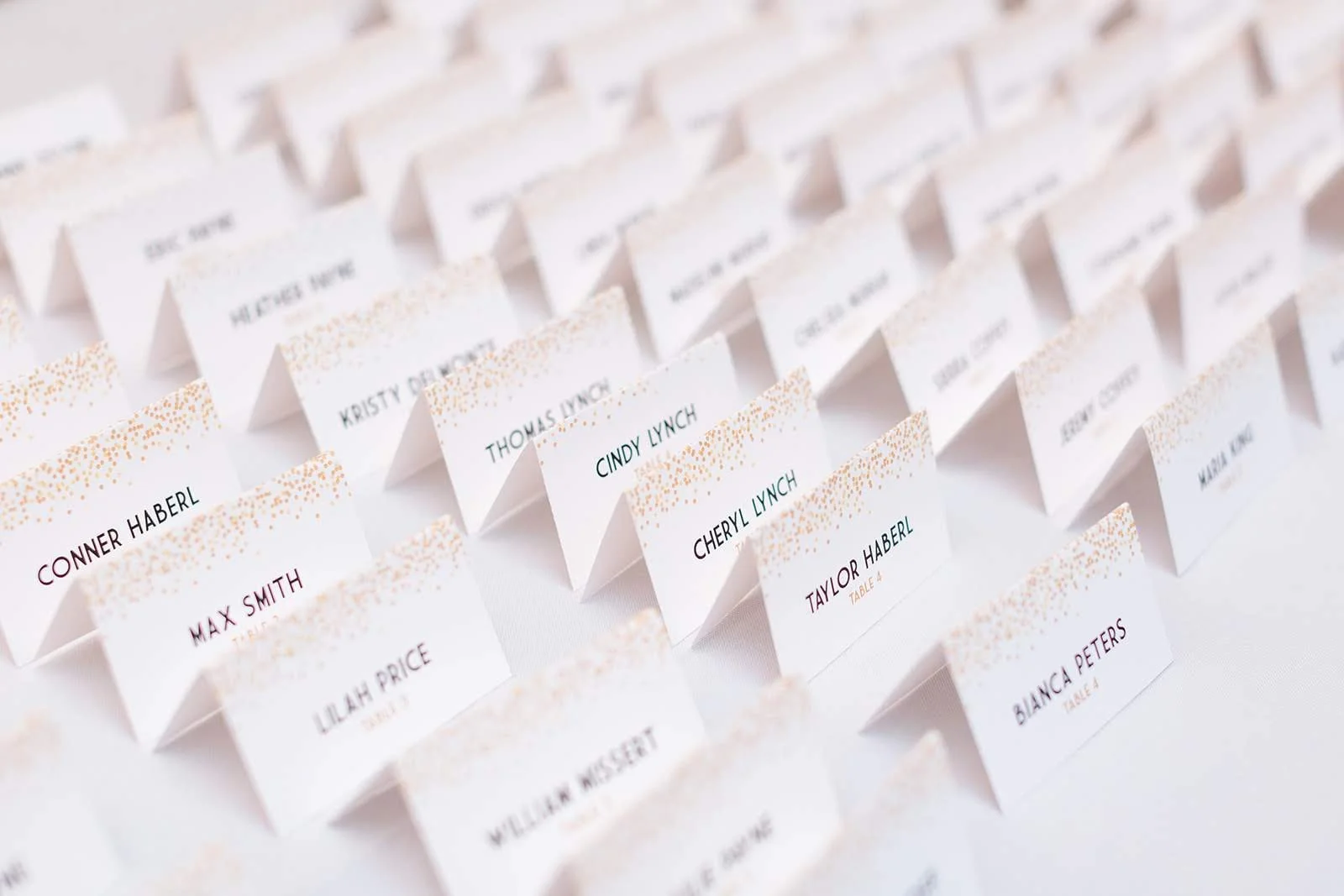 Closeup of wedding escort cards arranged in rows on a table.