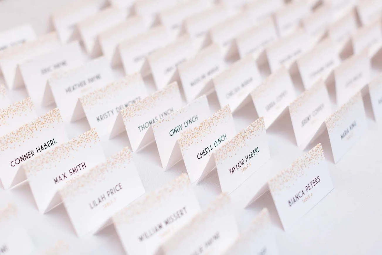 Wedding seating place cards arranged in rows on a white surface