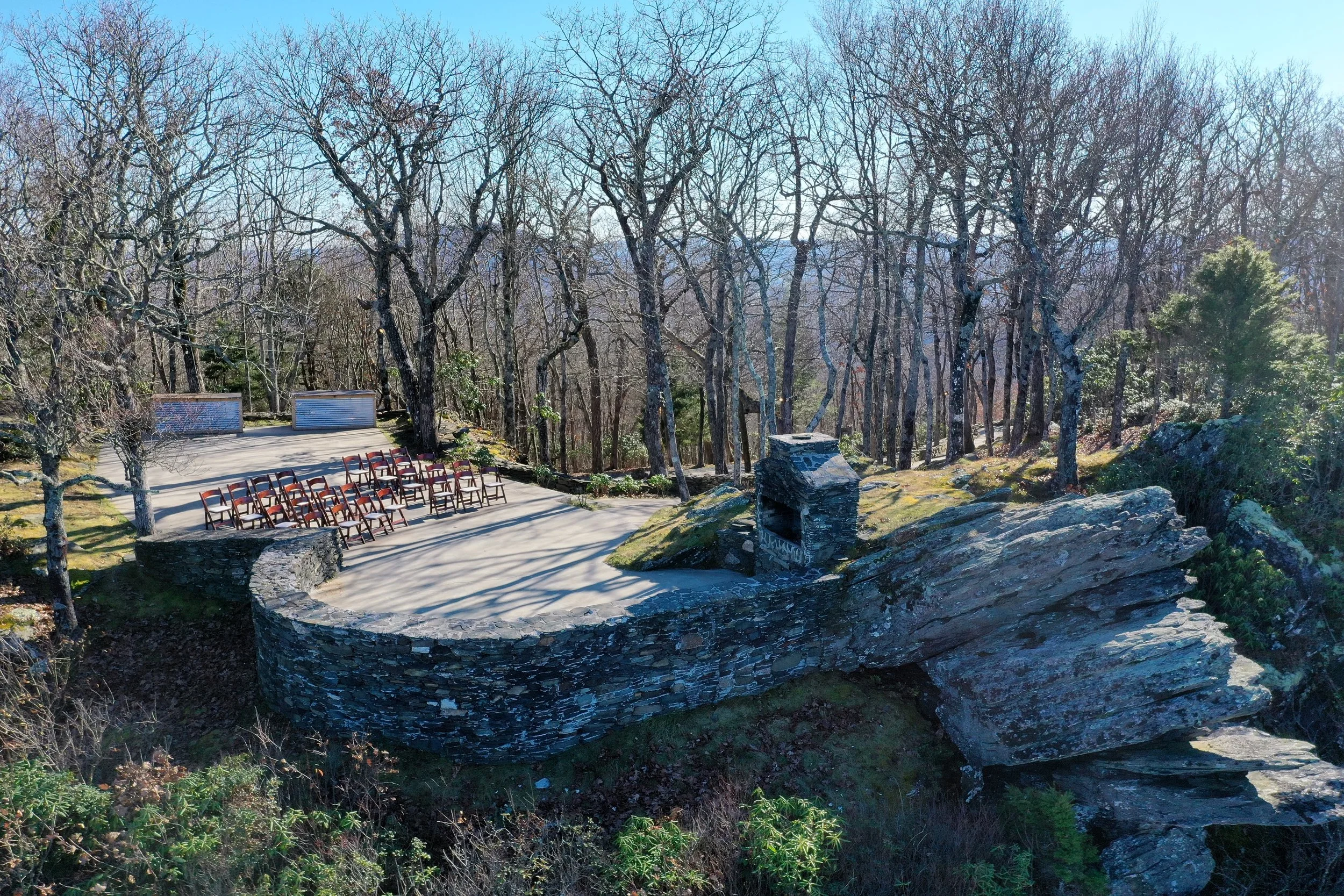 Stone terrace ceremony site on a mountain overlook with chairs set up among leafless trees