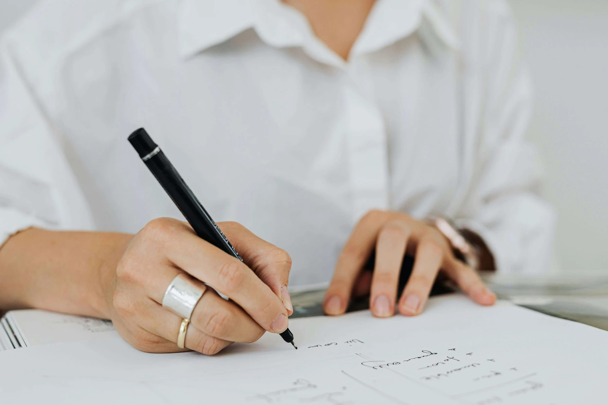 A ringed hand writes notes on paper. What happens if an employee refuses to complete a fitness for duty evaluation at work? An FFDE psychologist in Los Angeles, CA, can help guide both parties through the process.