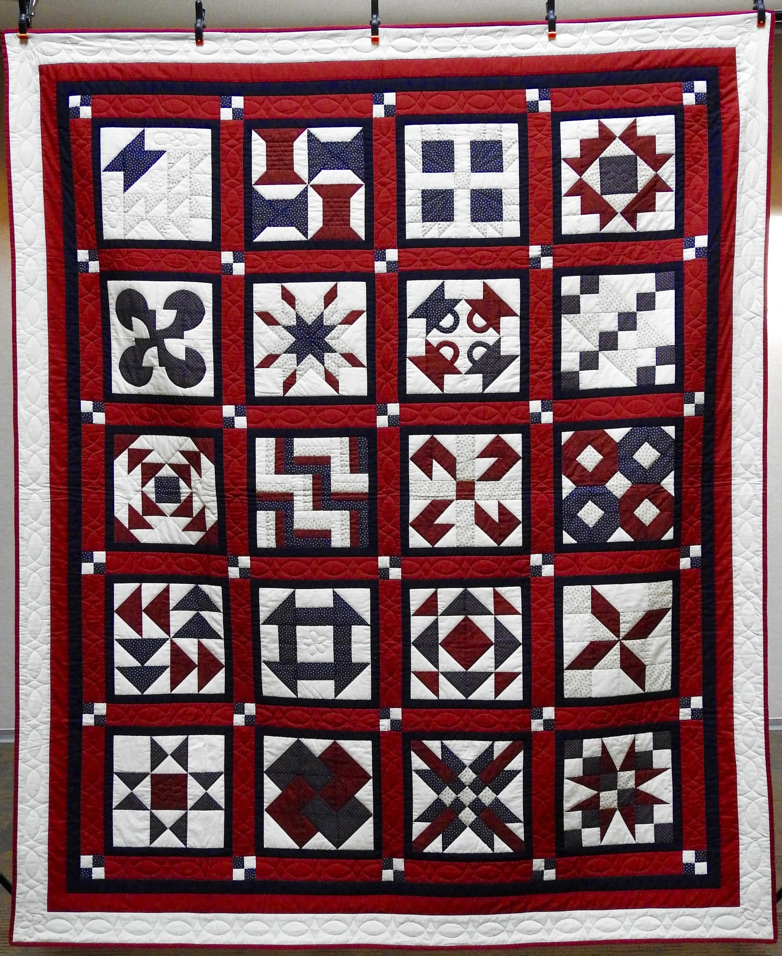 Red, White & Blue Sampler, Pieced & Hand Quilted by Isabel Leipprandt, Signed & Dated, donated by Wayne & Karen Moss, 73 x 98”