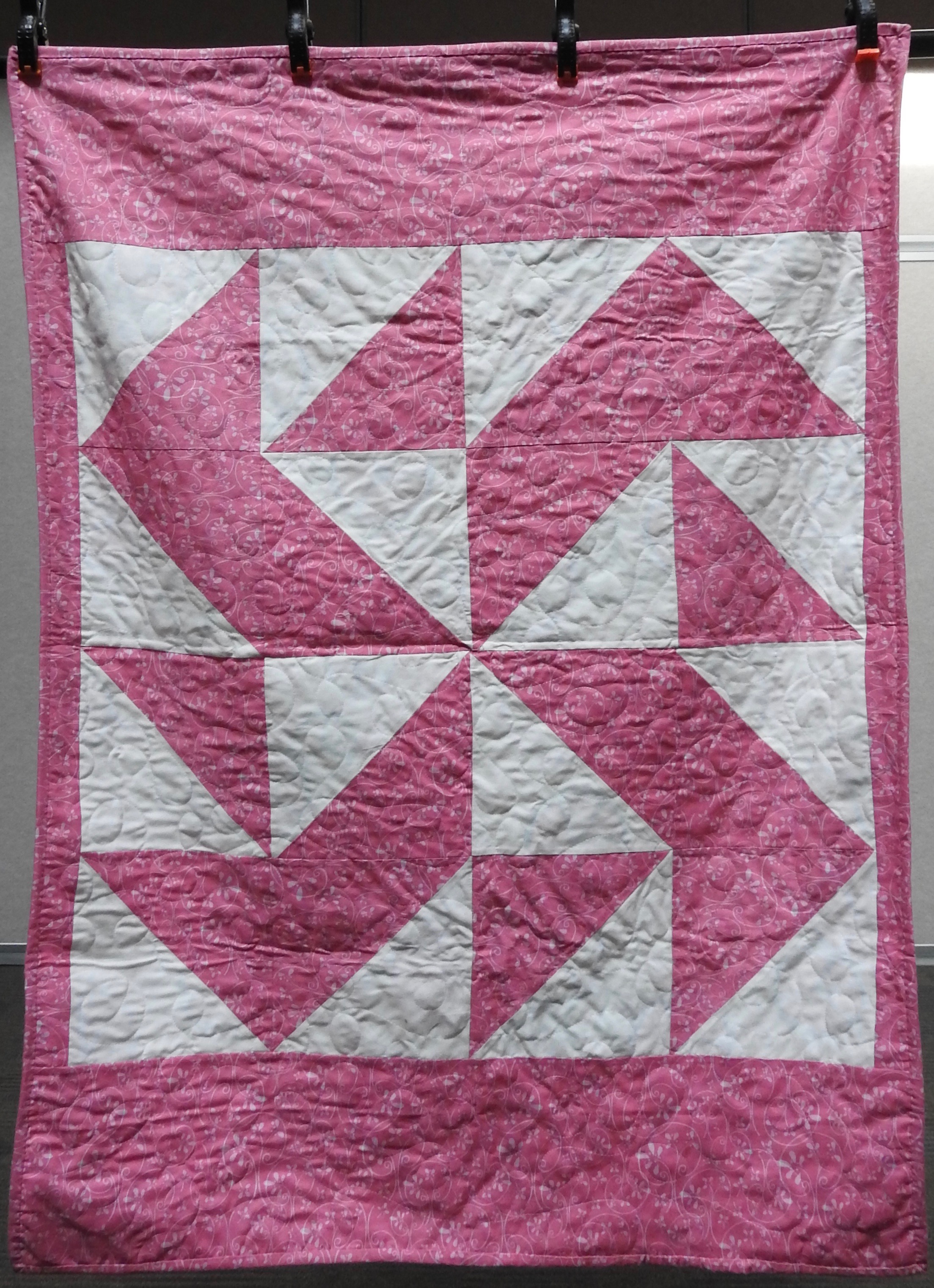  Twirling ‘Round Baby Quilt, Pieced, Plush Back, Edge to Edge Machine Quilted, donated anonymously, 38 x 51”