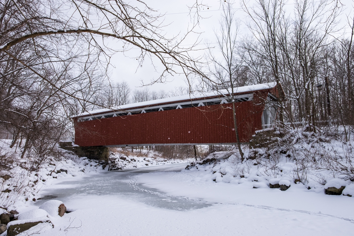 The Everett Covered Bridge and animal tracks crossing Furnace Run during a snowfall in winter, 2016.