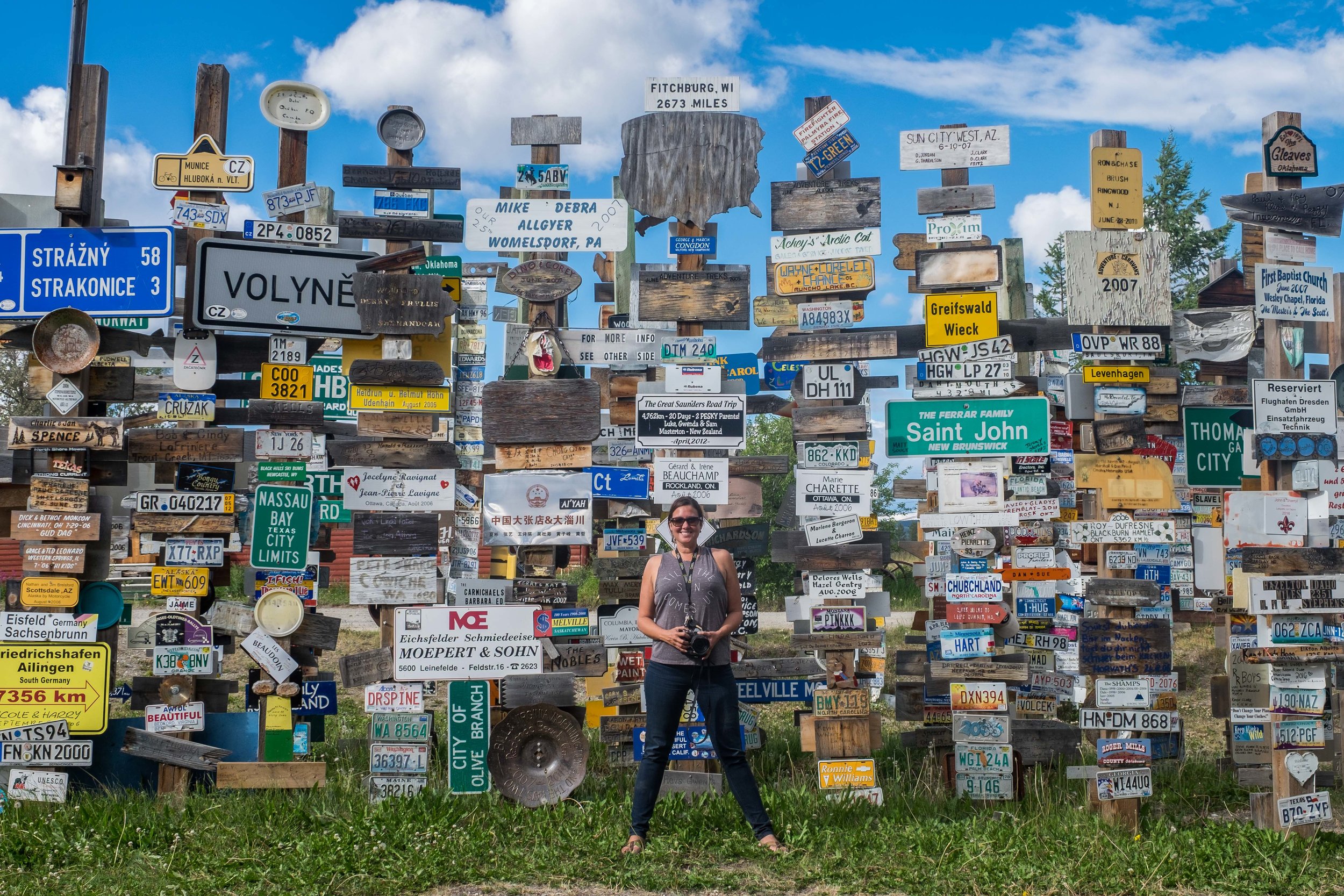 Stef is dwarfed beneath a collection of some 30,000 road signs that can be found at the Sign Post Forest in the Watson Lake area of the Yukon Territory.