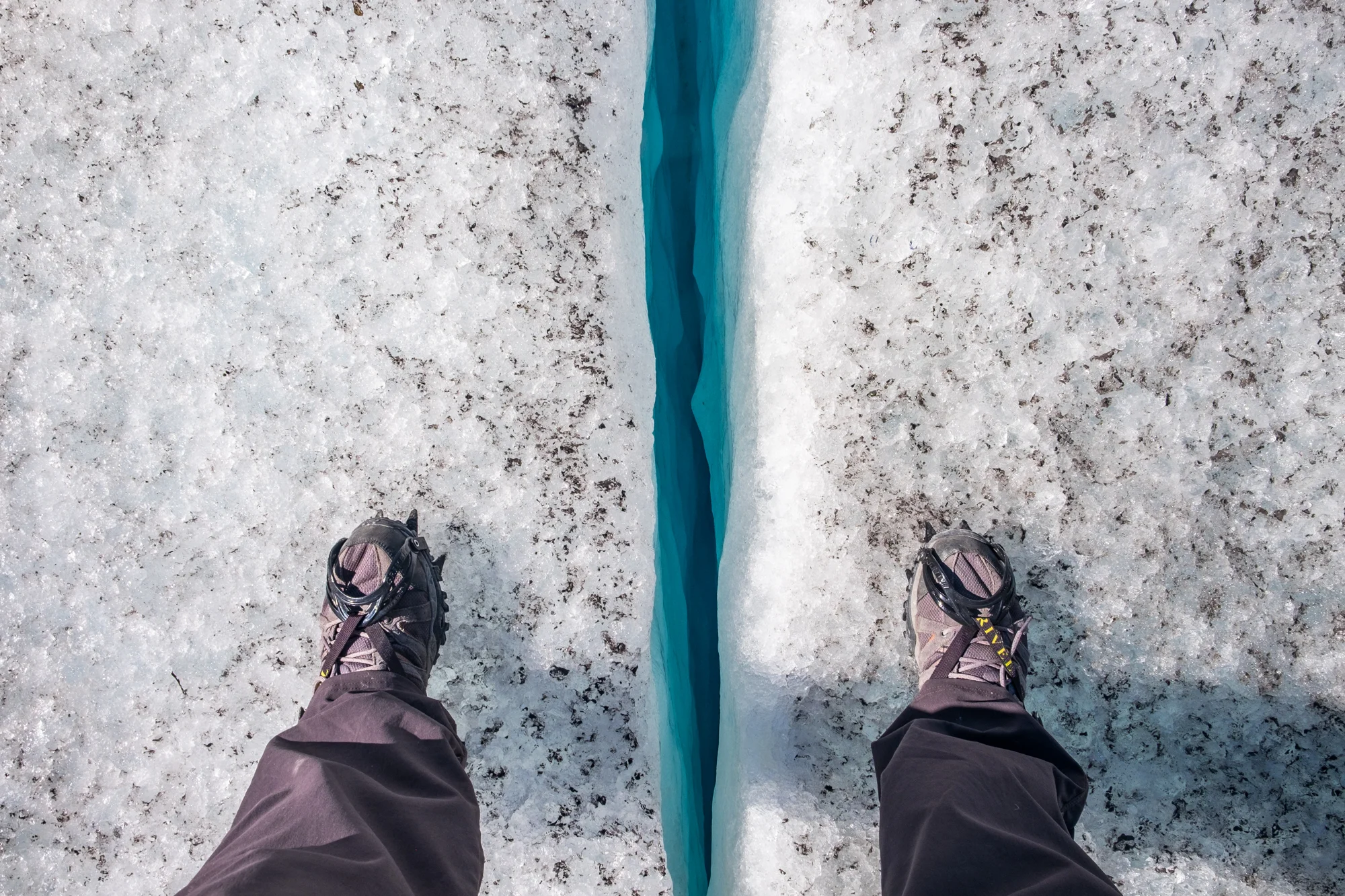 Jon straddles a crevasse on the Godwin Glacier near Kenai Fjords National Park in Alaska.