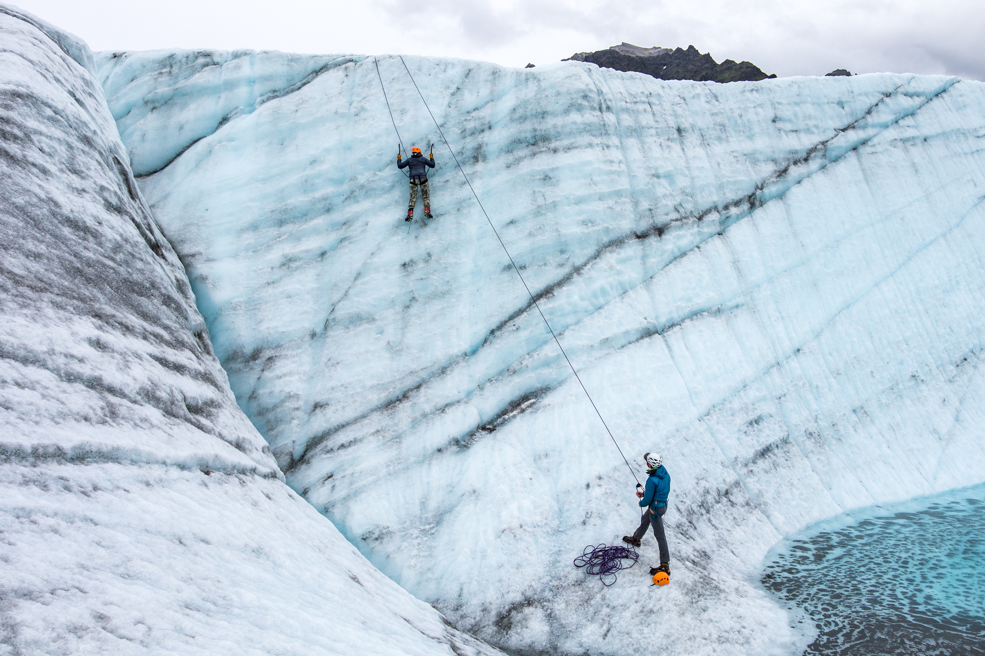 Stef learns to ice climb with her belay support standing below, a technical guide from St. Elias Guides named Kelly, an all-star climber and our backpacking guide through the park.