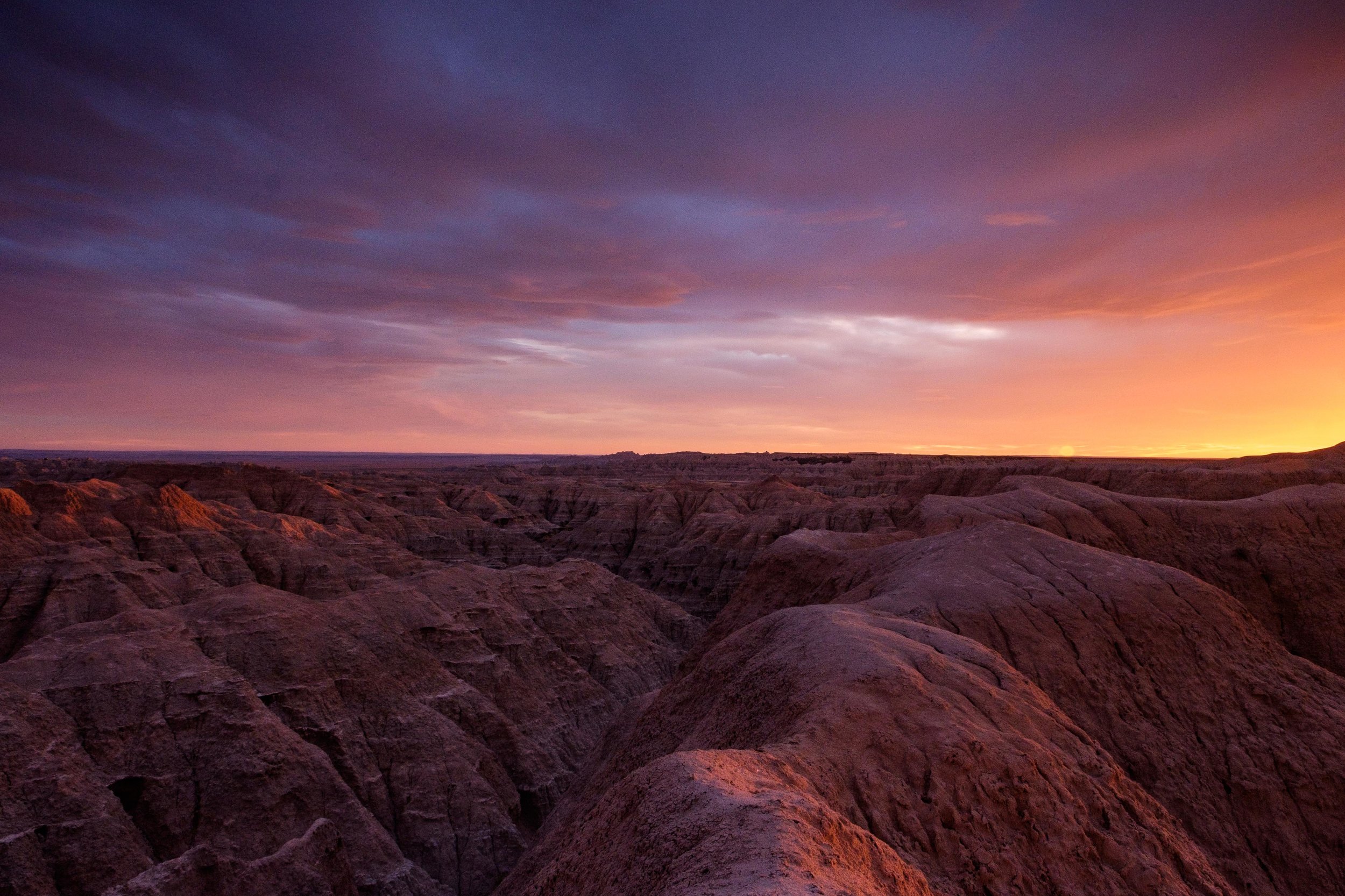 An October sunset warms the badlands landscape near the Pinnacles entrance of the park along Sage Creek Rim Road. 