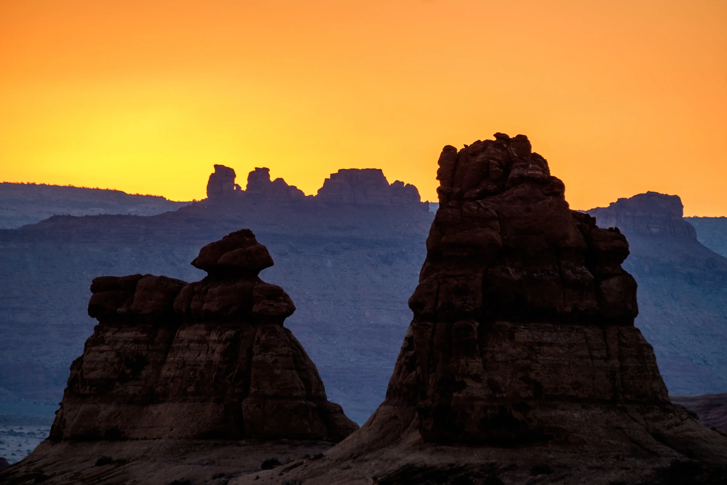 Sandstone formations sillouetted in a sunset sky as seen in the Windows section of the park.