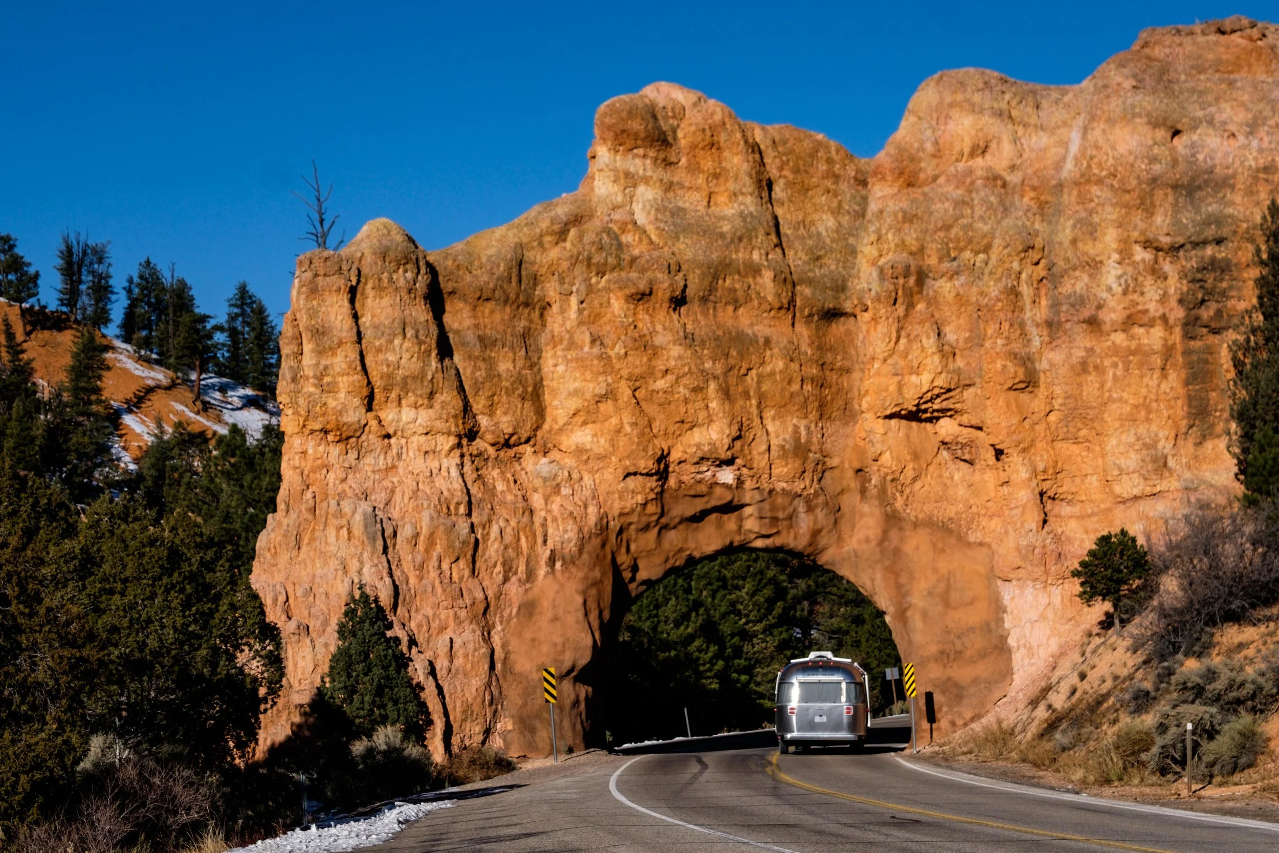 Wally the Airstream makes way through a natural arch in the Dixie National Forest en route to the park.