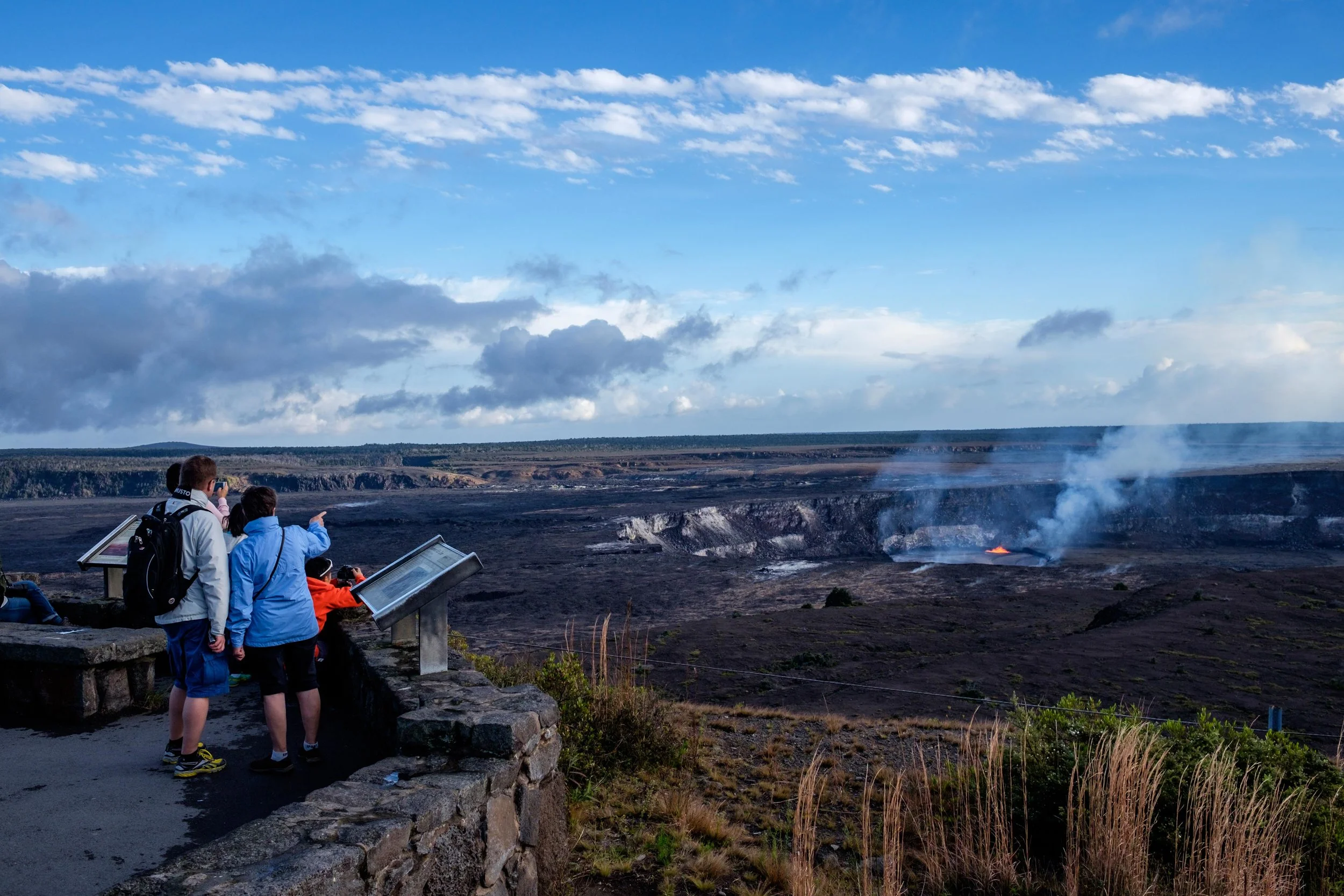 Hawai'i Volcanoes National Park visitors watch the wonder of the Halema'uma'u Crater erupting 100 feet away.