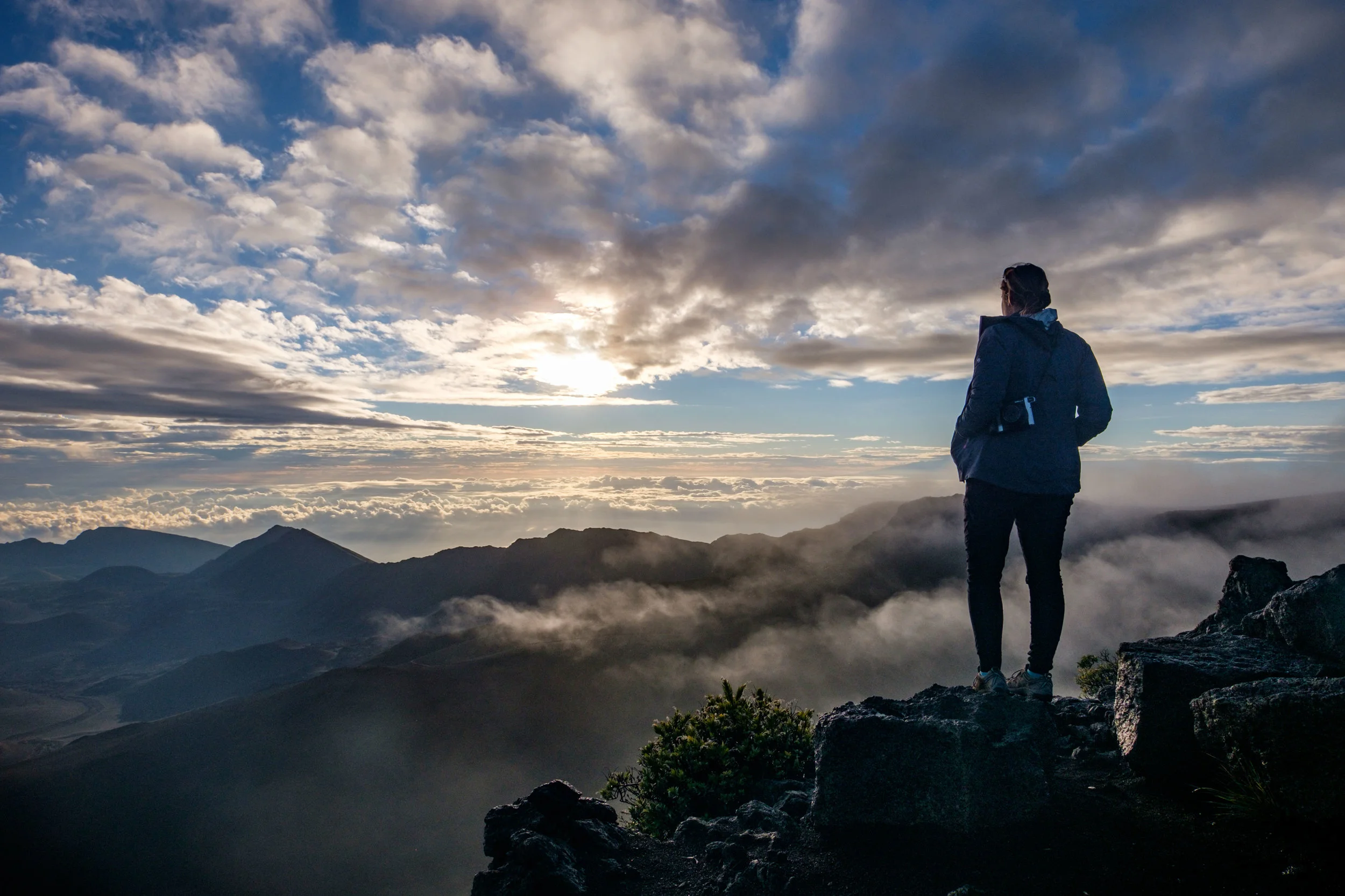 Standing above the clouds atop Maui's Haleakalā Crater during sunrise. 