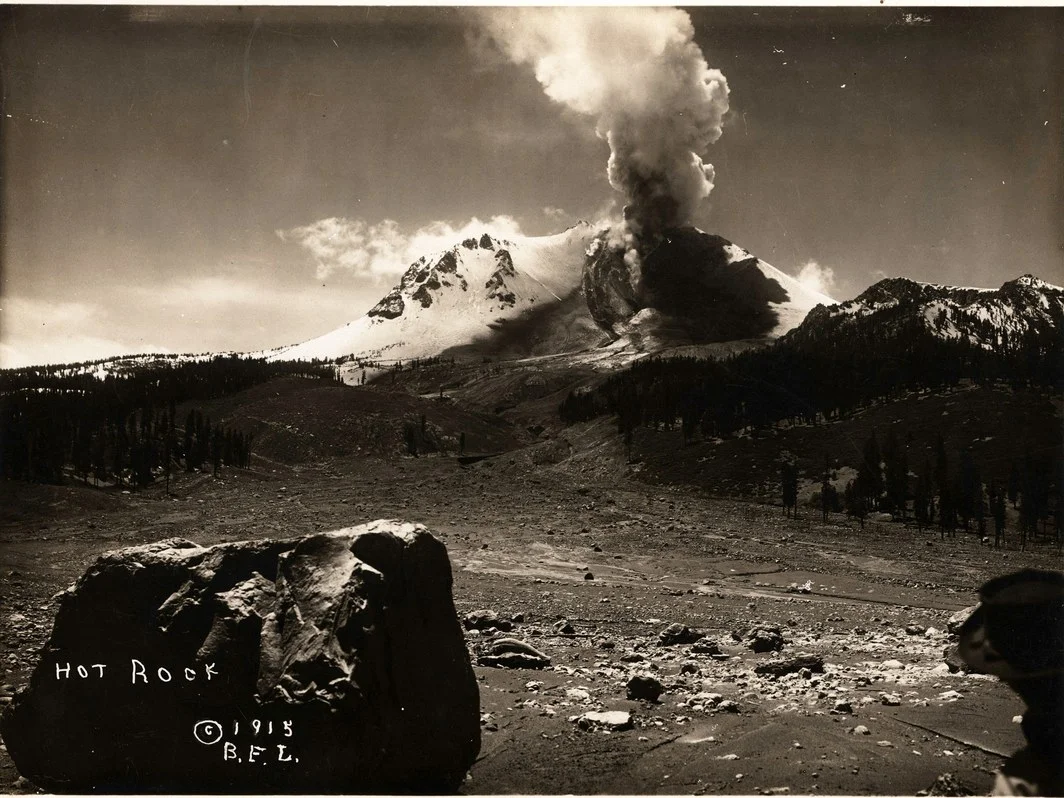 Steam rising from Lassen Peak after the devastating1915 eruption and a smoldering rock in the foreground. Credit: B.F. Loomis/NPS/Library of Congress