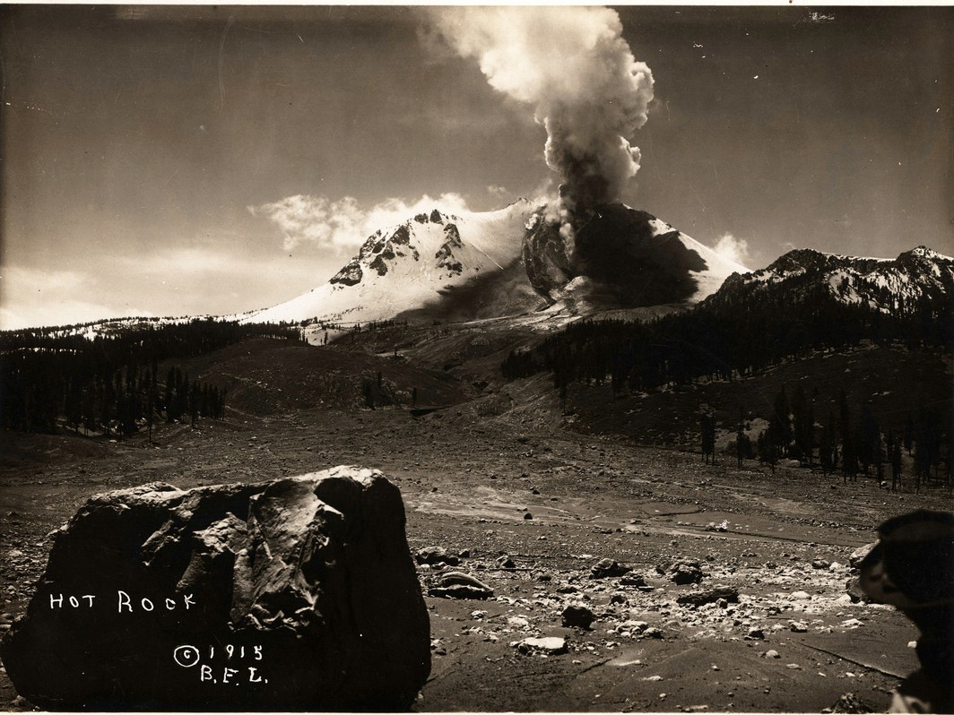 Steam rising from Lassen Peak after the devastating1915 eruption and a smoldering rock in the foreground. Credit: B.F. Loomis/NPS/Library of Congress