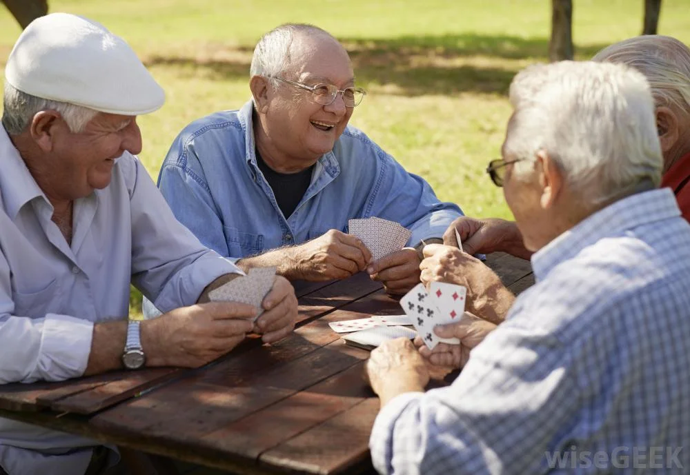 old-men-sitting-at-wooden-table-playing-cards.jpg