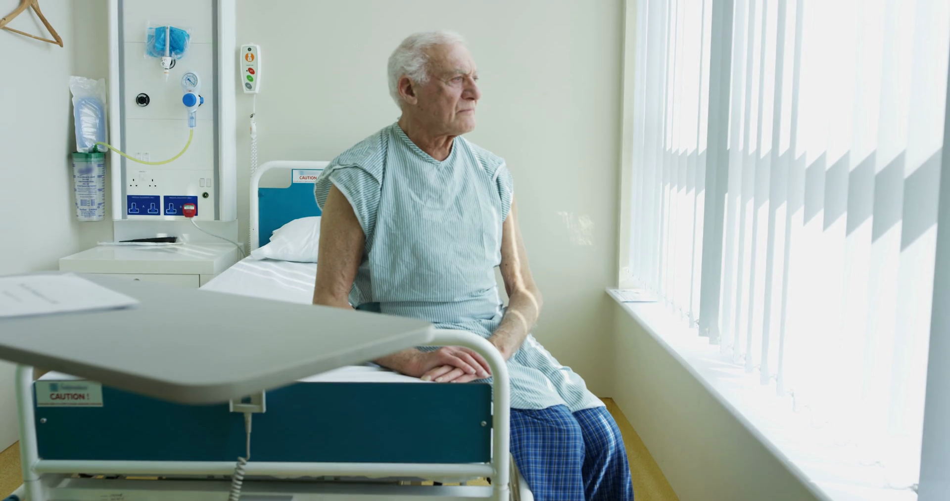 4k-portrait-of-smiling-elderly-patient-sitting-on-his-bed-in-hospital-room_bfgpzq7ftx_thumbnail-full01.png