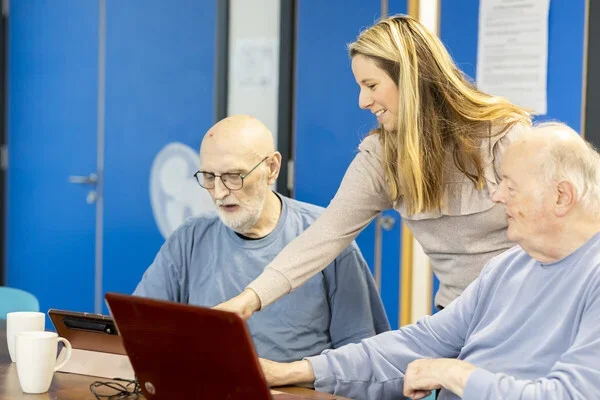 woman helping two men at a computer.webp