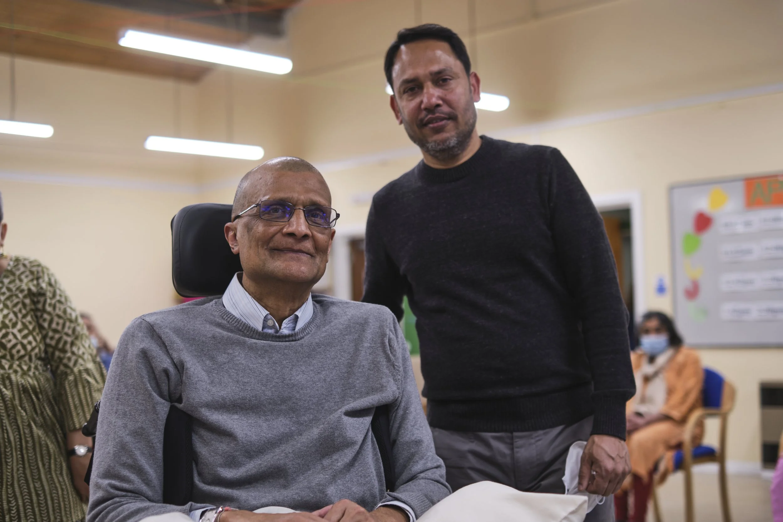 older disabled man with a younger man supporting.jpg