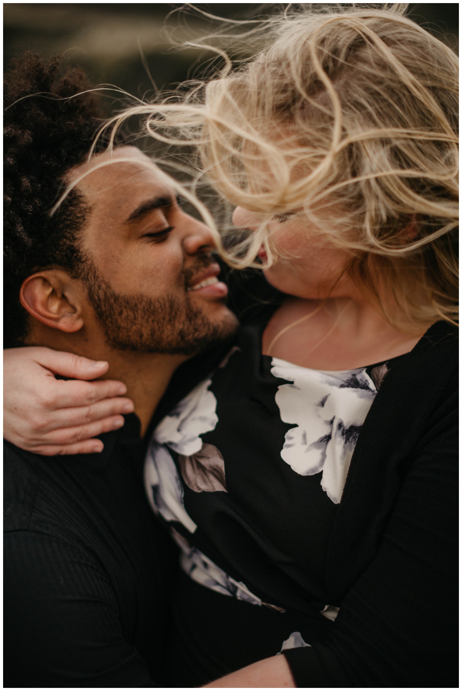Couple sitting together with the wind blowing their hair