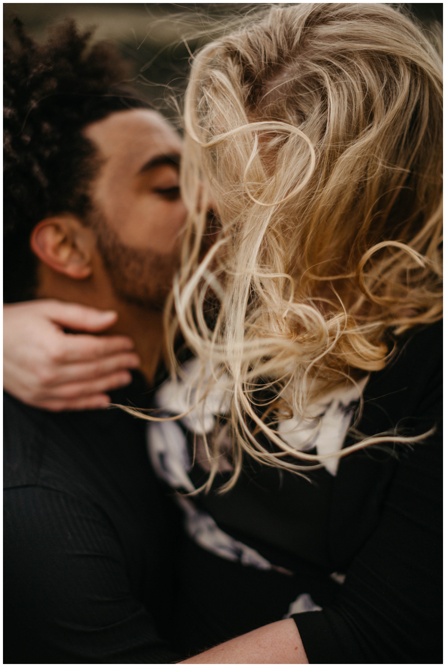 Couple kissing while the wind blows her hair.