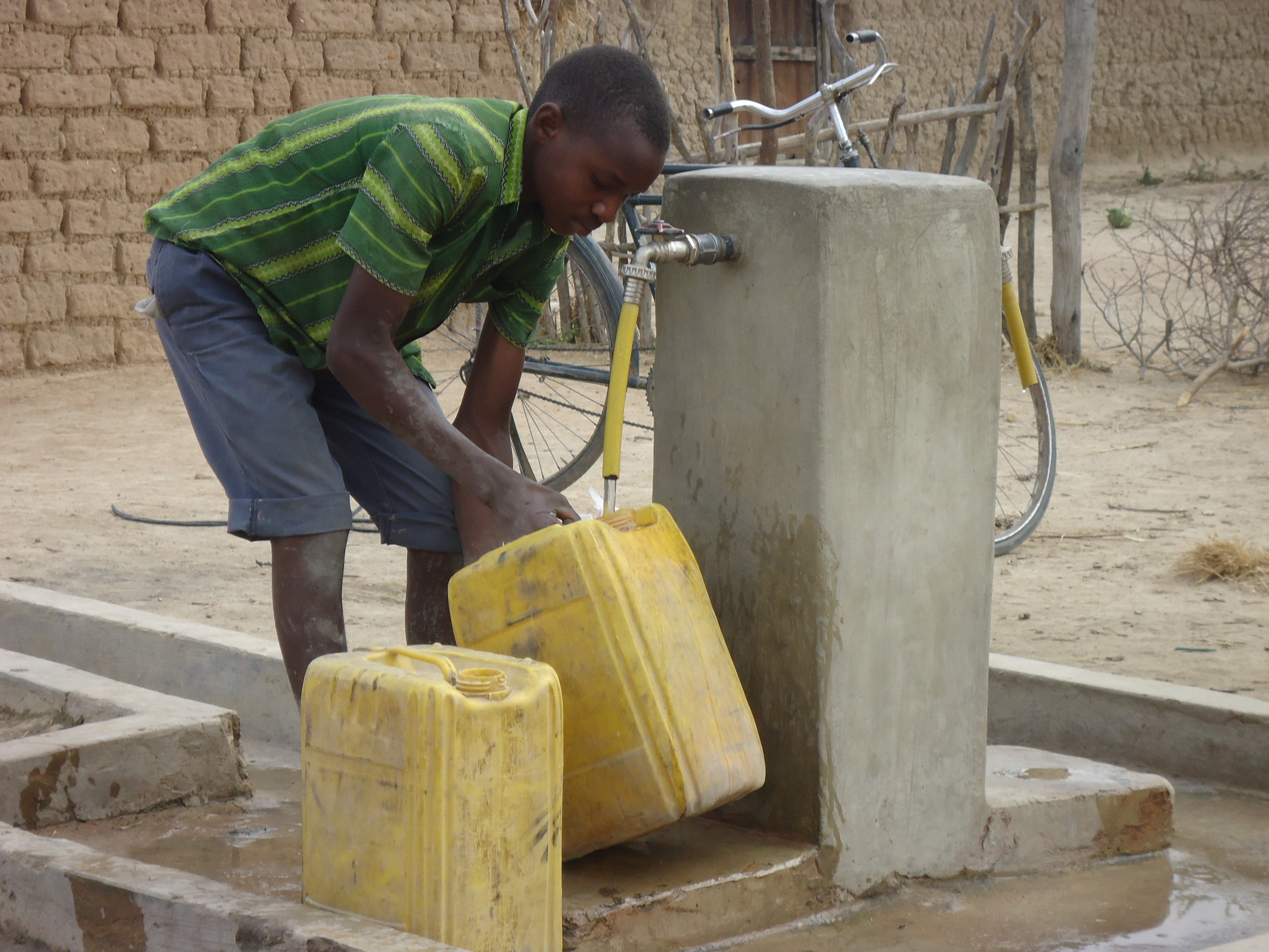 Boy collects water from  DP in Ihumwa village.JPG