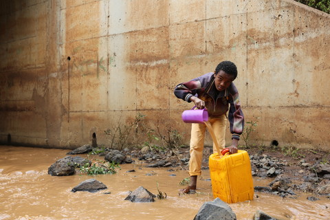 Gobena collects muddy river water for his family. Image by WaterAid/ Behailu Shiferaw