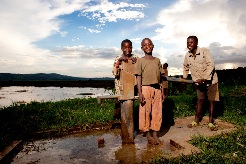Children enjoying new water pump, charity: water
