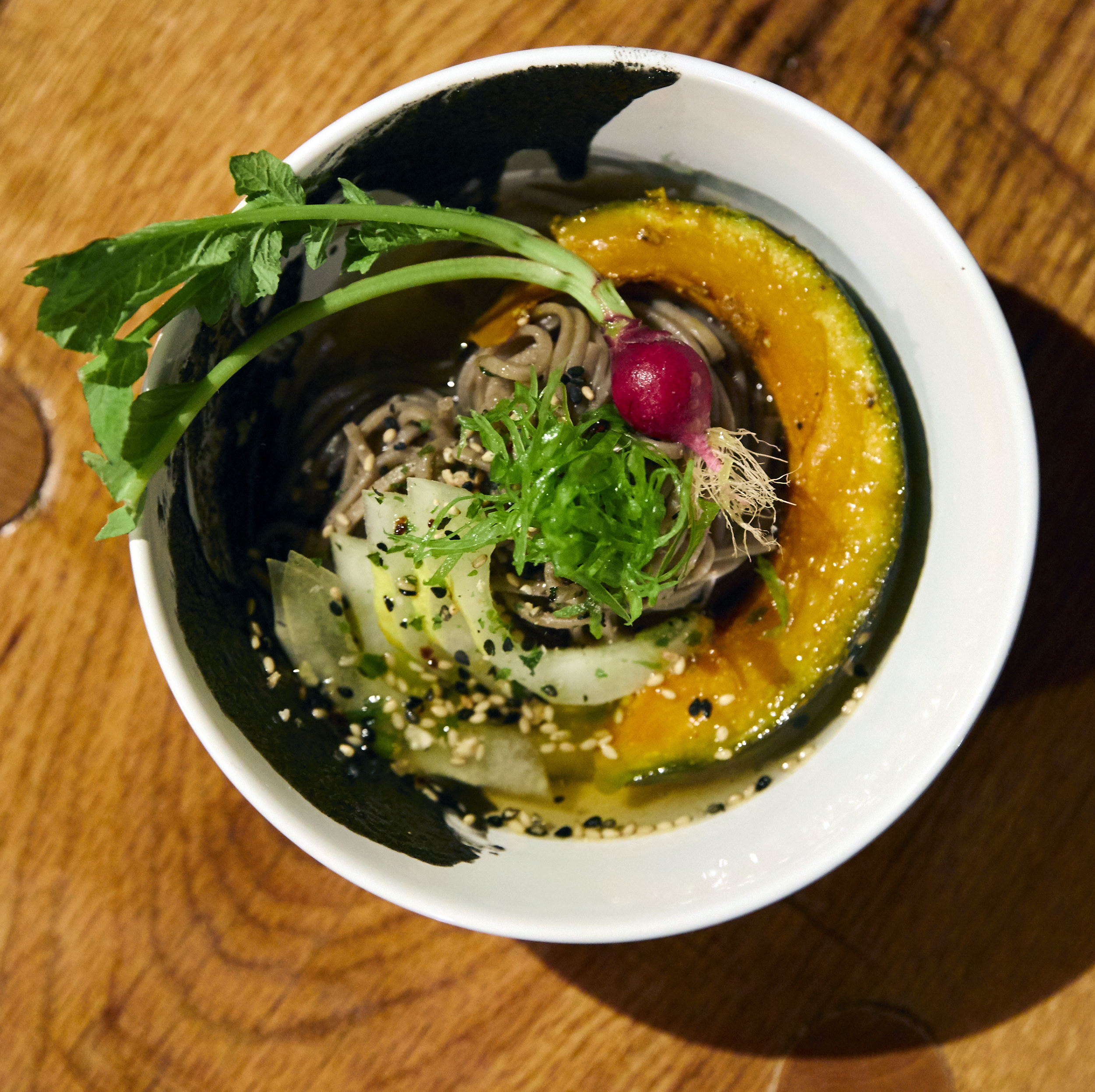 Chilled soba noodles with lapsang souchong dashi, roast kabocha, lemon cucumber, tiny radish, burnt honey yuzu furikake, and black sesame paste. Photo by Johnny Fogg.