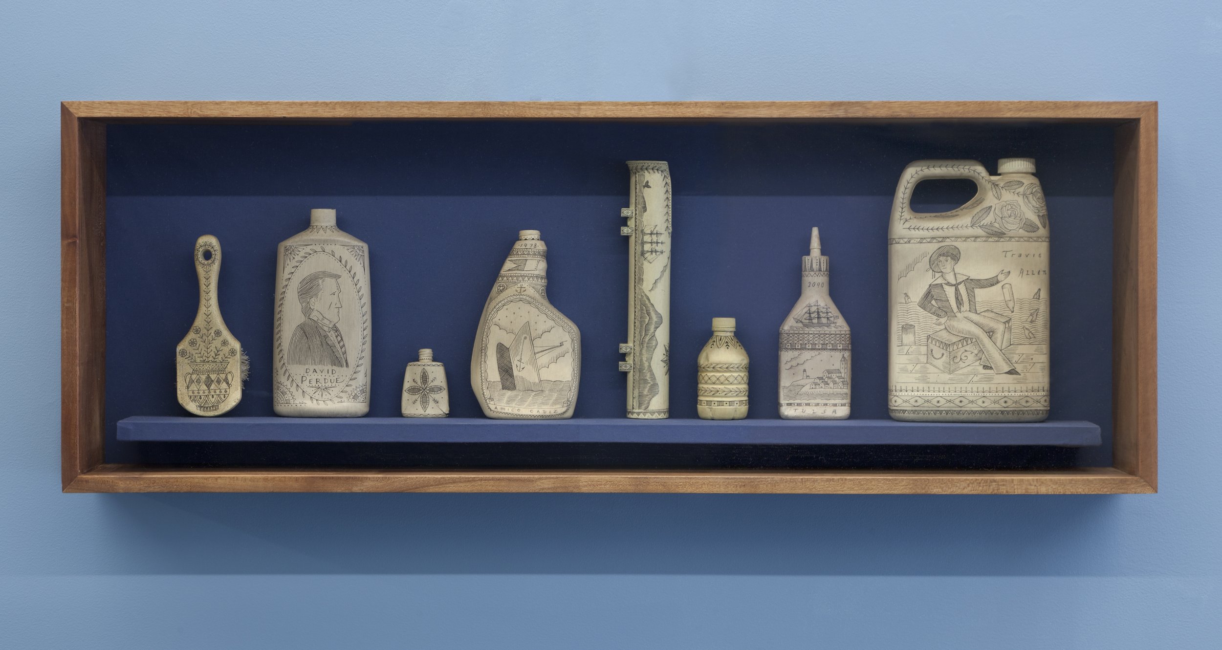   Eight Articles Selected for the Poly S. Tyrene Memorial Maritime Museum , 2021. Salvaged painted plastic in mahogany wood and glass case, 17.5” × 49.5” × 7”. Photo courtesy of Will Howcroft for Praise Shadows Art Gallery.. 