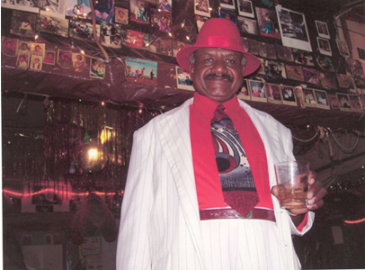 Mr. Seaberry standing in front of some of his collection of pictures, post cars, and other decorative items. - Kathleen Robbins, 2003