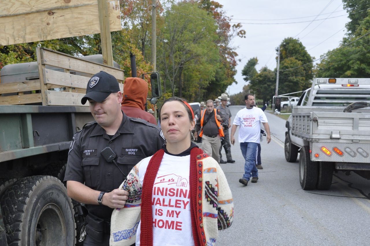 In October of 2012, Asha Canalos was arrested while blocking construction vehicles to the construction site of the Minisink Compressor Station, joining the first wave of New Yorkers to engage in civil disobedience in opposition to fracking infrastructure in the years after the Marcellus Shale 'gas boom.' It would be nearly two years before Minisink's case would be heard, but in the Fall of 2012, through FERC's 'tolling orders,' Minisink residents were prevented from going to court while the pipeline company was allowed to proceed cutting trees and beginning construction. Photographs (this and 3 previous images), Yorke Flynn, 2012.