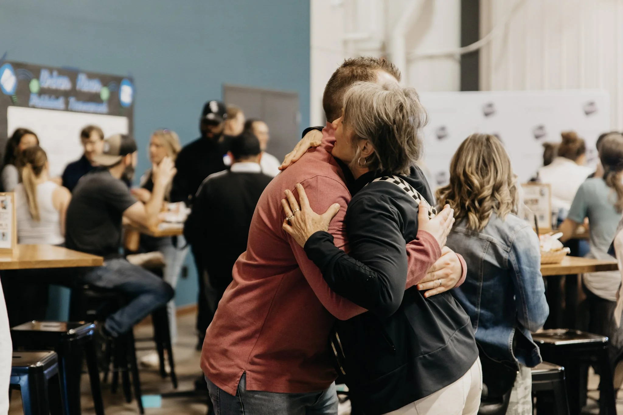 A man and woman embrace in a friendly hug