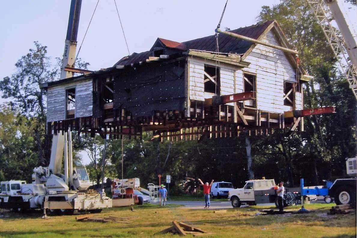The upper-half of the house being lifted by a crane. 