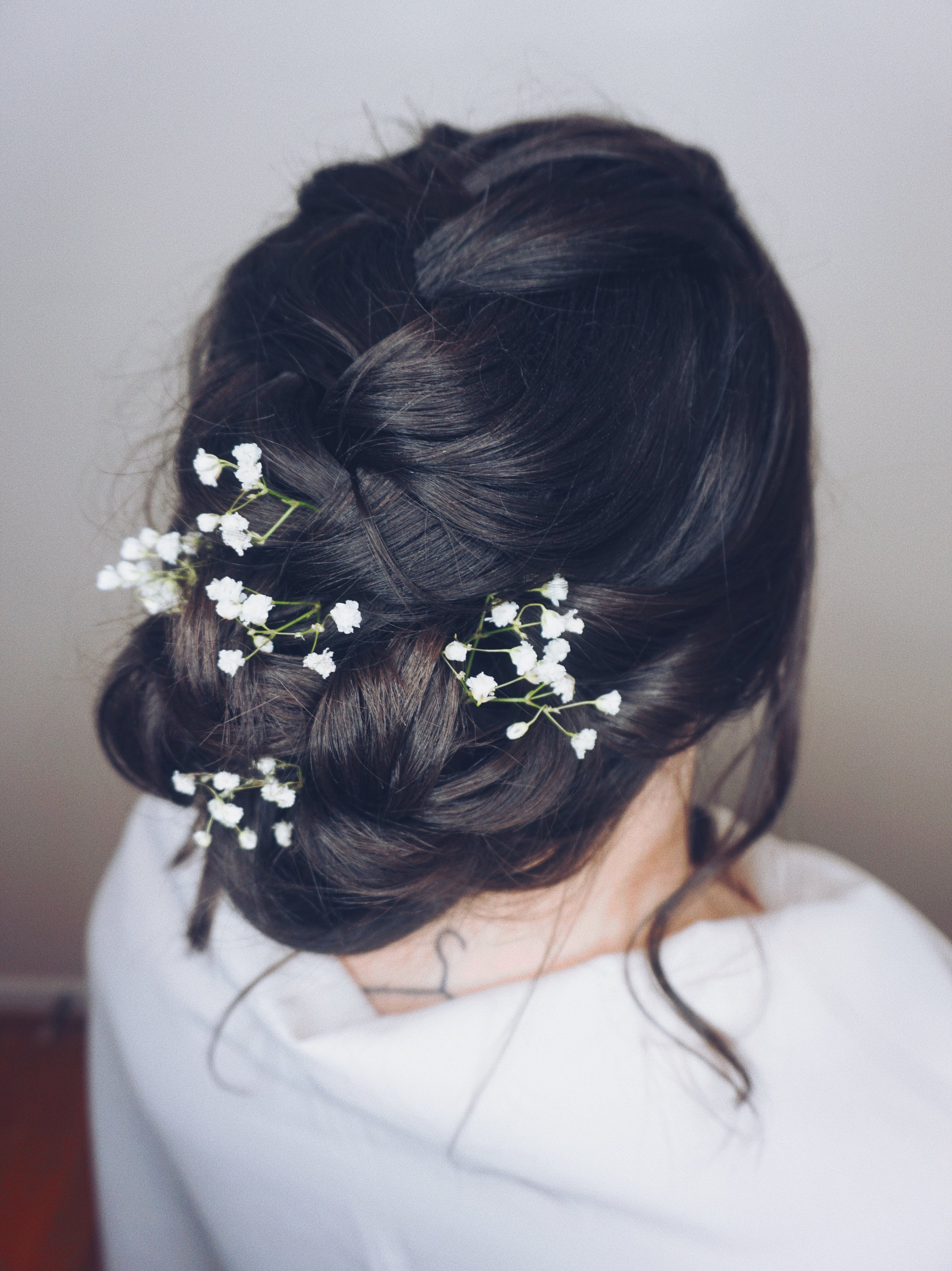 Romantic textured low bun with braids & florals