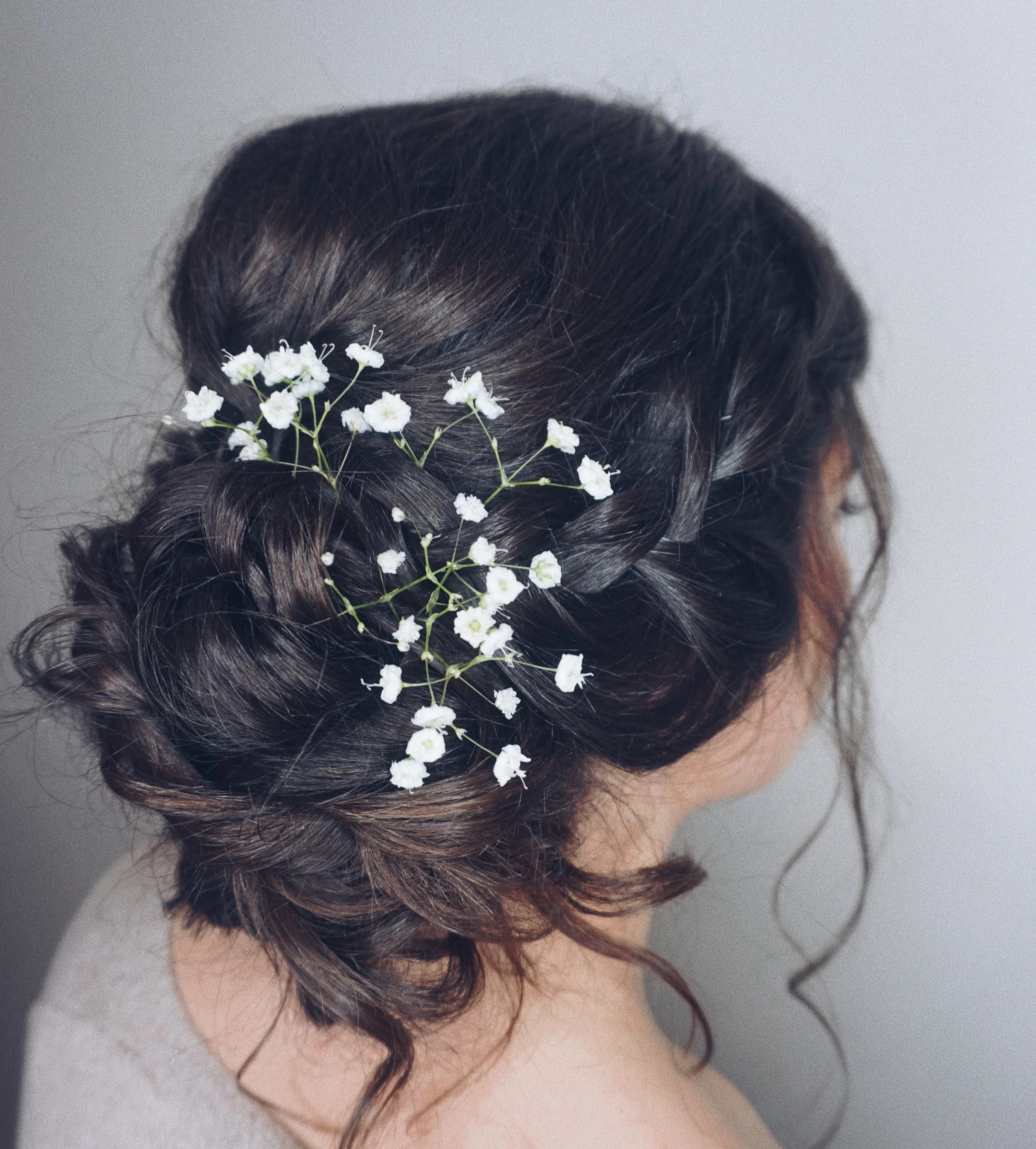 Textured side low bun with braids & florals