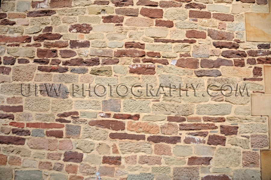 Crude stone wall colored ancient building Background Stock Image